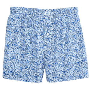 A pair of blue and white floral-patterned men's boxer shorts with an elastic waistband and a button fly.